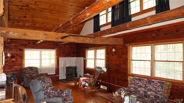 living room with beamed ceiling, a wood stove, a towering ceiling, wood ceiling, and hardwood / wood-style flooring