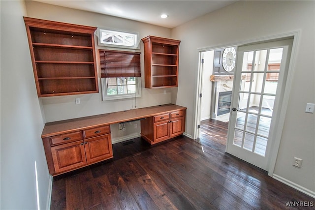 office area with built in desk, dark hardwood / wood-style floors, and french doors