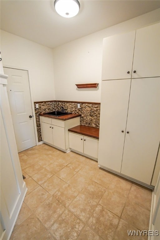 interior space with sink and backsplash