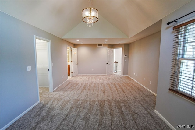 unfurnished room with carpet floors, a chandelier, and vaulted ceiling