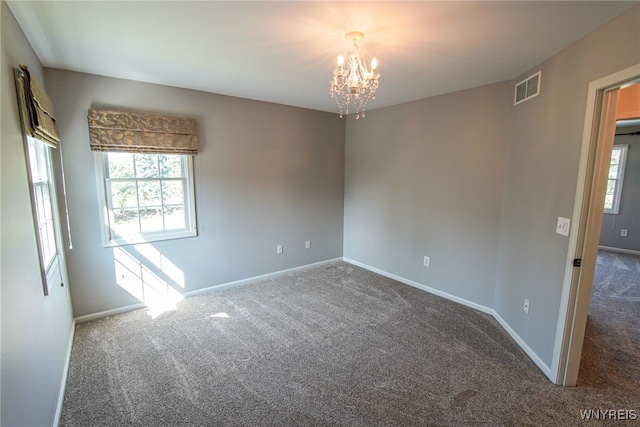 unfurnished room with carpet and a notable chandelier