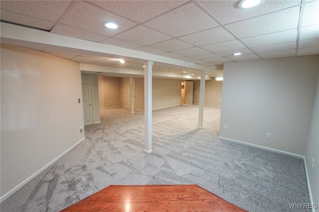 basement featuring carpet flooring and a paneled ceiling