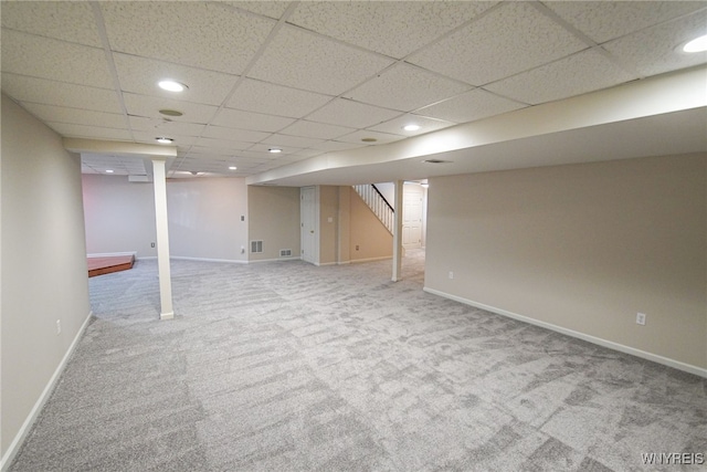 basement featuring a drop ceiling and carpet