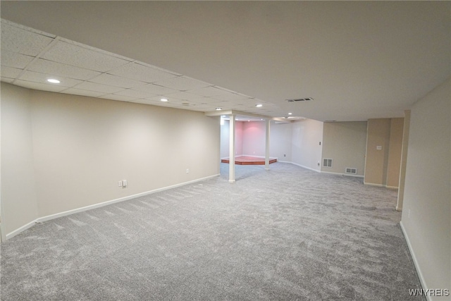 basement featuring a paneled ceiling and carpet flooring