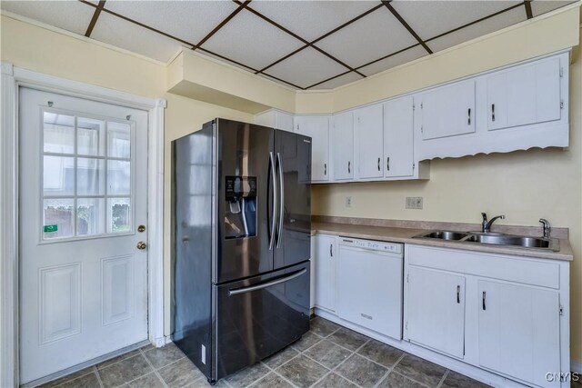 kitchen featuring white cabinets, white dishwasher, sink, black fridge with ice dispenser, and a paneled ceiling