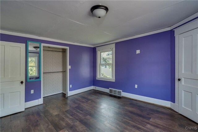 unfurnished bedroom with multiple windows and dark wood-type flooring