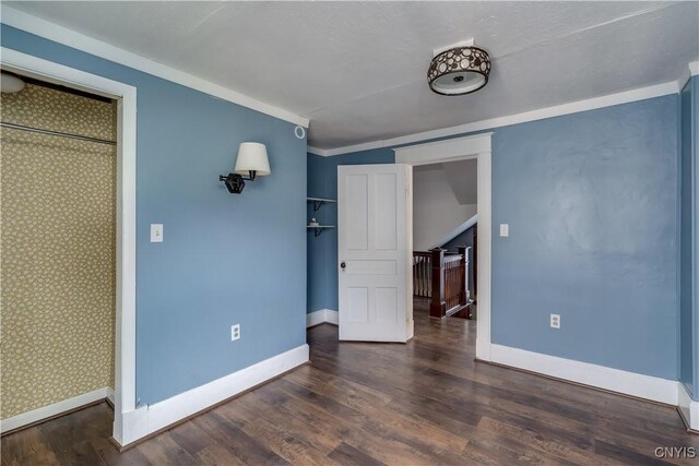 unfurnished room with dark wood-type flooring and ornamental molding