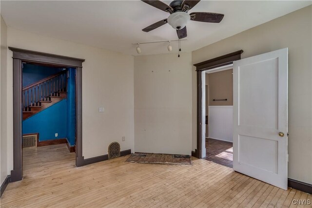 unfurnished room featuring track lighting, ceiling fan, and light hardwood / wood-style flooring