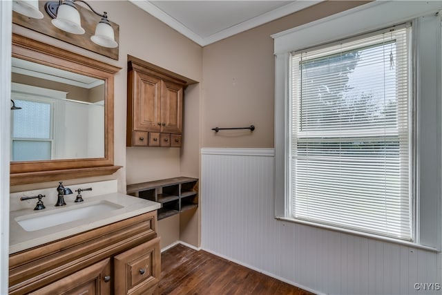 bathroom featuring a wealth of natural light, hardwood / wood-style flooring, ornamental molding, and vanity