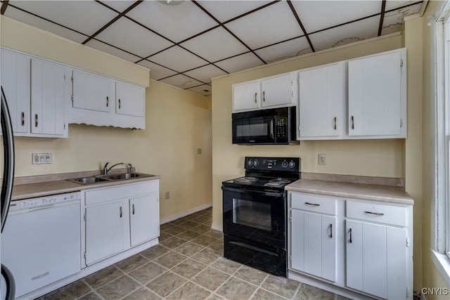 kitchen featuring black appliances, sink, a drop ceiling, white cabinets, and light tile patterned flooring