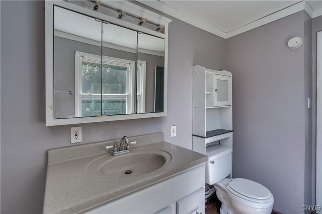 bathroom with hardwood / wood-style floors, toilet, ornamental molding, and vanity