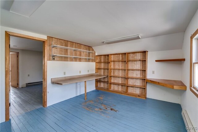 unfurnished office featuring a baseboard radiator, a healthy amount of sunlight, and dark hardwood / wood-style floors