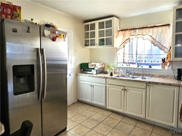 kitchen with white cabinets, sink, light tile patterned flooring, stainless steel fridge with ice dispenser, and ornamental molding