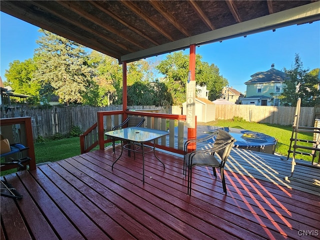 deck featuring a lawn and a storage unit