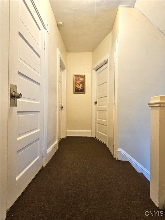 hall featuring dark colored carpet