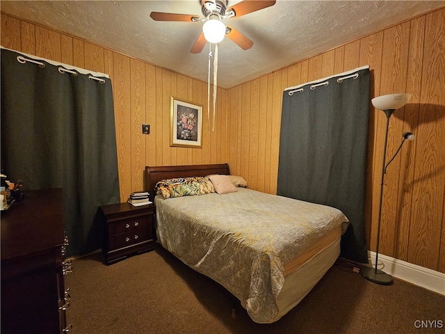 carpeted bedroom featuring a textured ceiling, ceiling fan, and wooden walls