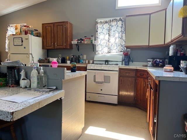 kitchen with lofted ceiling, light carpet, and white appliances