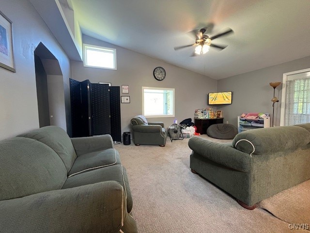 carpeted living room with ceiling fan and vaulted ceiling