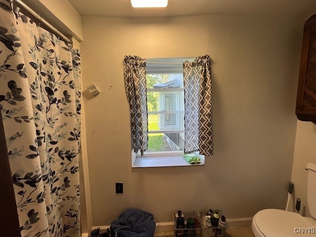 bathroom featuring curtained shower and toilet