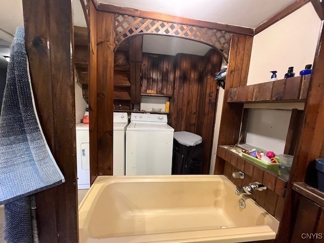 bathroom featuring washing machine and dryer and a washtub