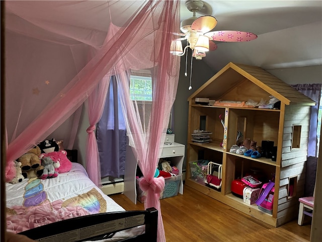 bedroom with ceiling fan, vaulted ceiling, baseboard heating, and hardwood / wood-style floors