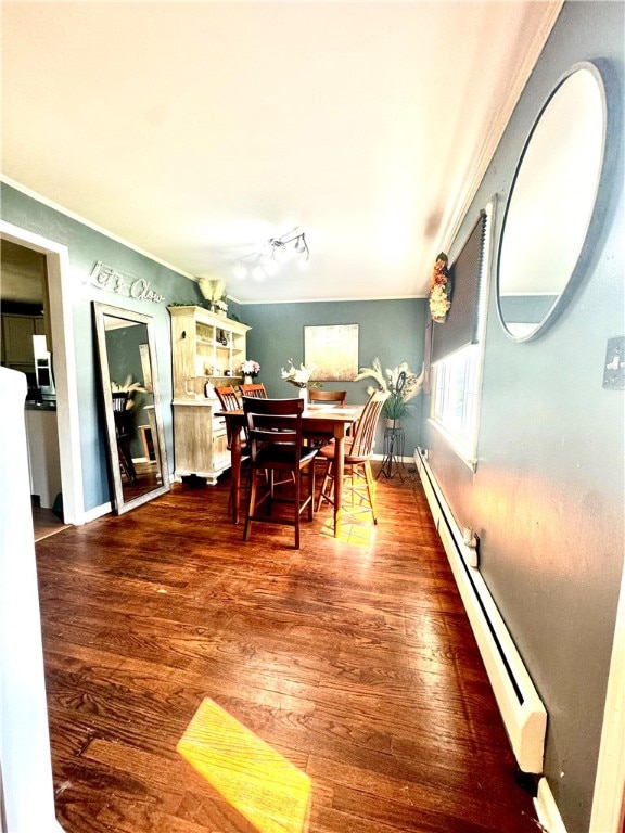 dining area with a baseboard radiator, ornamental molding, and dark wood-type flooring