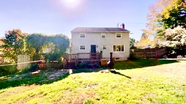 rear view of house with a lawn and a wooden deck