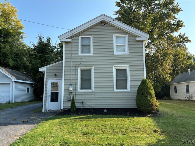 view of front facade with an outbuilding, a front yard, and a garage