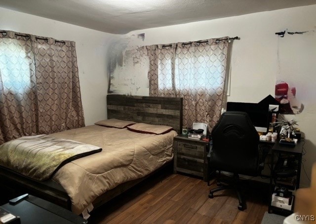 bedroom with dark wood-type flooring