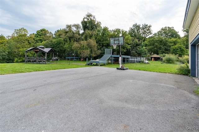 exterior space with a trampoline and a lawn