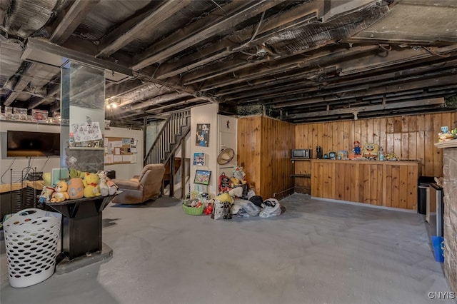 basement featuring wooden walls