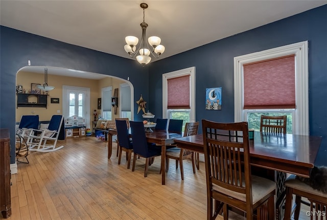 dining space featuring plenty of natural light, a notable chandelier, and wood-type flooring