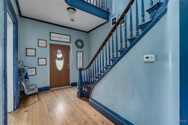 foyer entrance featuring ornamental molding and wood-type flooring