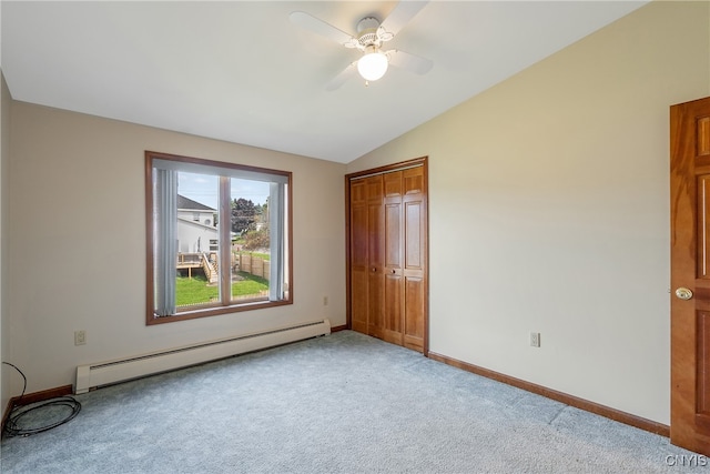 unfurnished bedroom with vaulted ceiling, light carpet, a closet, ceiling fan, and baseboard heating