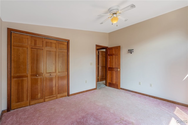 unfurnished bedroom featuring lofted ceiling, light colored carpet, ceiling fan, and a closet