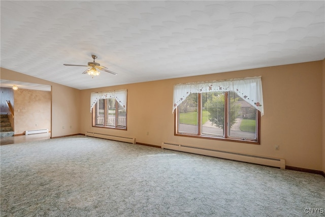 carpeted spare room with baseboard heating, vaulted ceiling, and ceiling fan