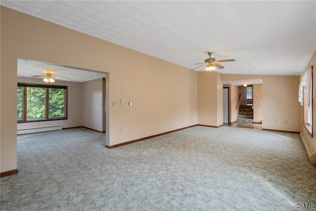 carpeted empty room featuring lofted ceiling, baseboard heating, and ceiling fan