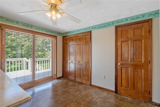 unfurnished bedroom featuring access to exterior, ceiling fan, and a closet