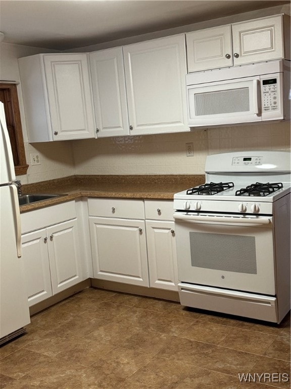 kitchen featuring decorative backsplash, sink, white cabinets, and white appliances