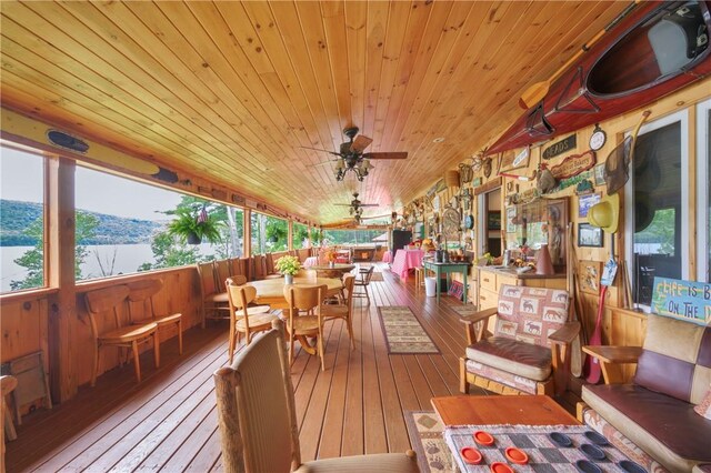 sunroom / solarium featuring a water view, wooden ceiling, vaulted ceiling, and ceiling fan