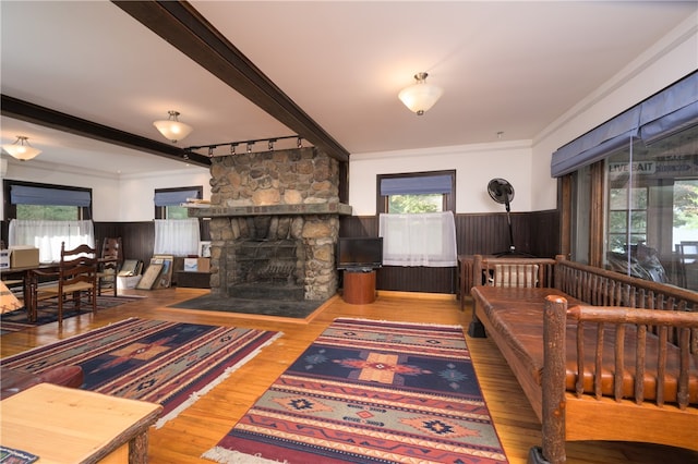 living room featuring hardwood / wood-style flooring, crown molding, and a wealth of natural light