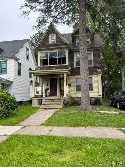 view of front of home with a front yard and a porch