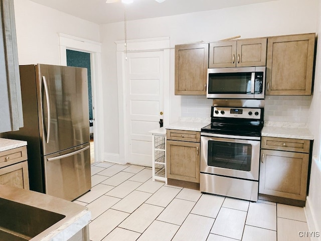 kitchen featuring ceiling fan, appliances with stainless steel finishes, and tasteful backsplash