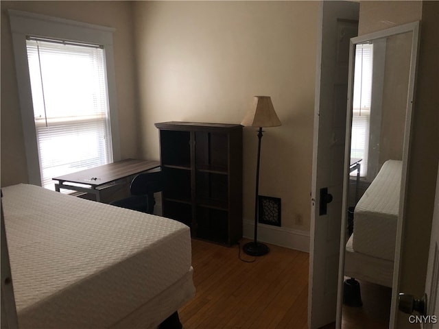 bedroom with hardwood / wood-style floors and multiple windows