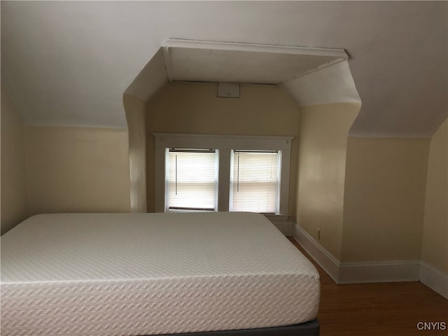 bedroom with vaulted ceiling and hardwood / wood-style flooring