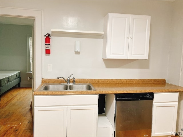 kitchen with hardwood / wood-style floors, sink, white cabinetry, and stainless steel dishwasher