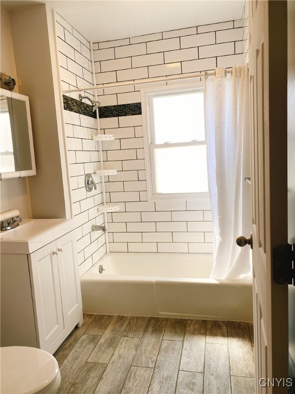 full bathroom featuring toilet, sink, shower / tub combo, and wood-type flooring