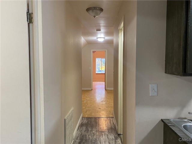 hall featuring hardwood / wood-style floors and sink