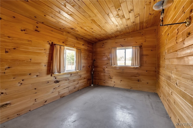 spare room featuring wood ceiling, wood walls, lofted ceiling, and concrete flooring