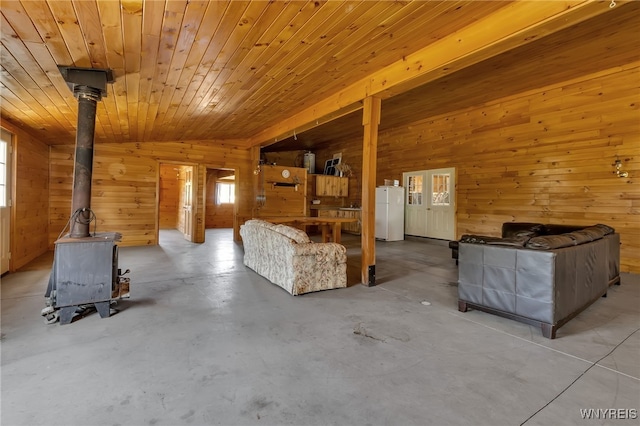 unfurnished living room with wooden ceiling, a wood stove, and wood walls